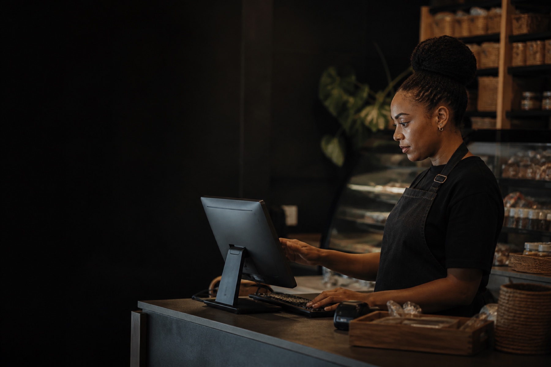 A small-business operator setting up a Windows point-of-sale workstation at the counter.